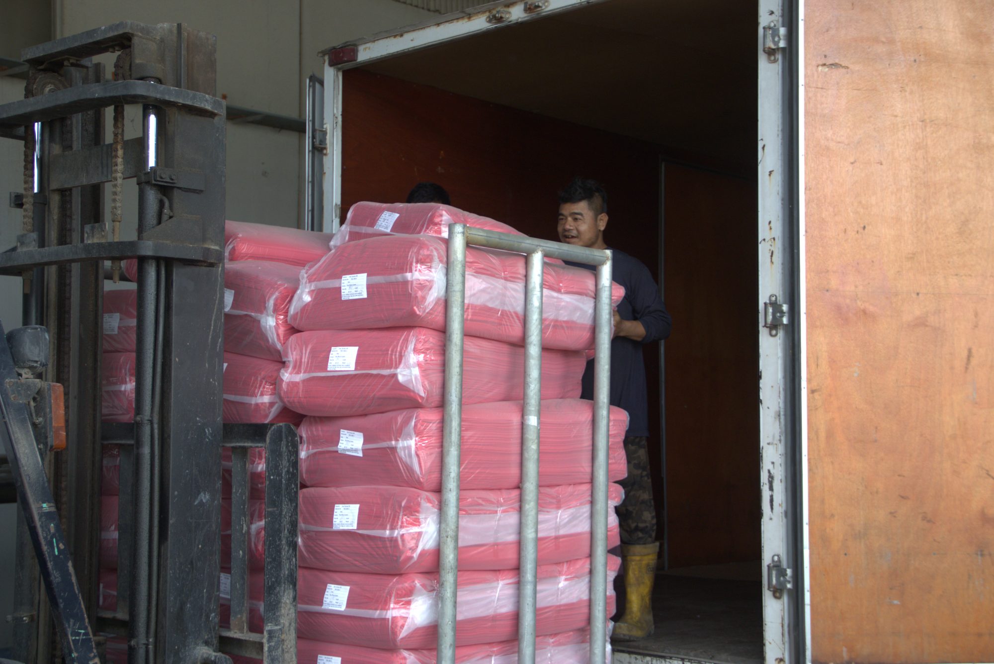 Finished fabric rolls being loaded onto delivery truck